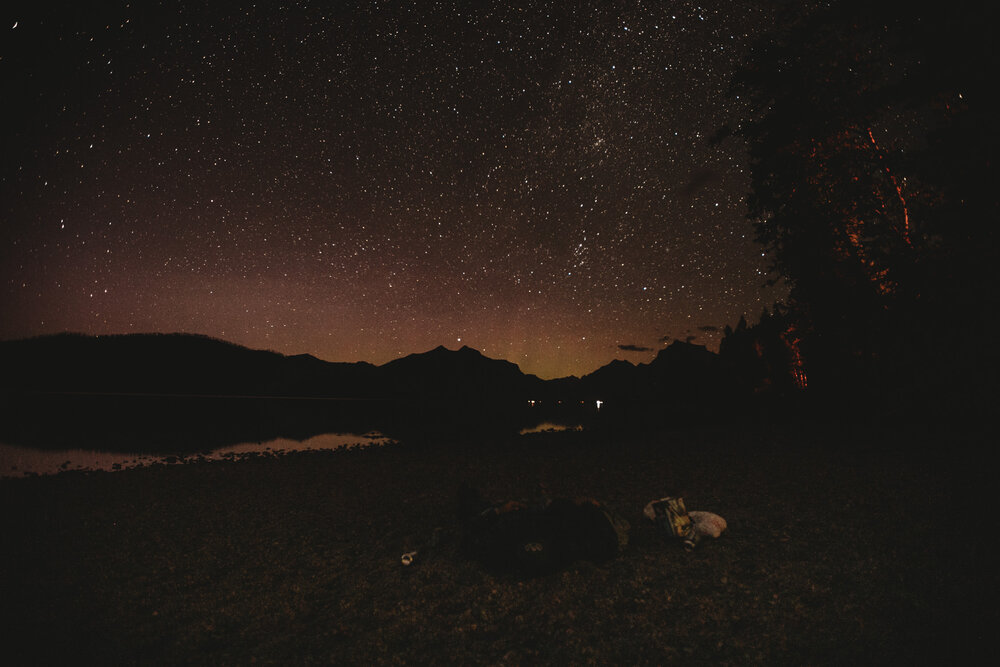 Ali and Tyler-Moss laying together under the stars at the end of their elopement day.