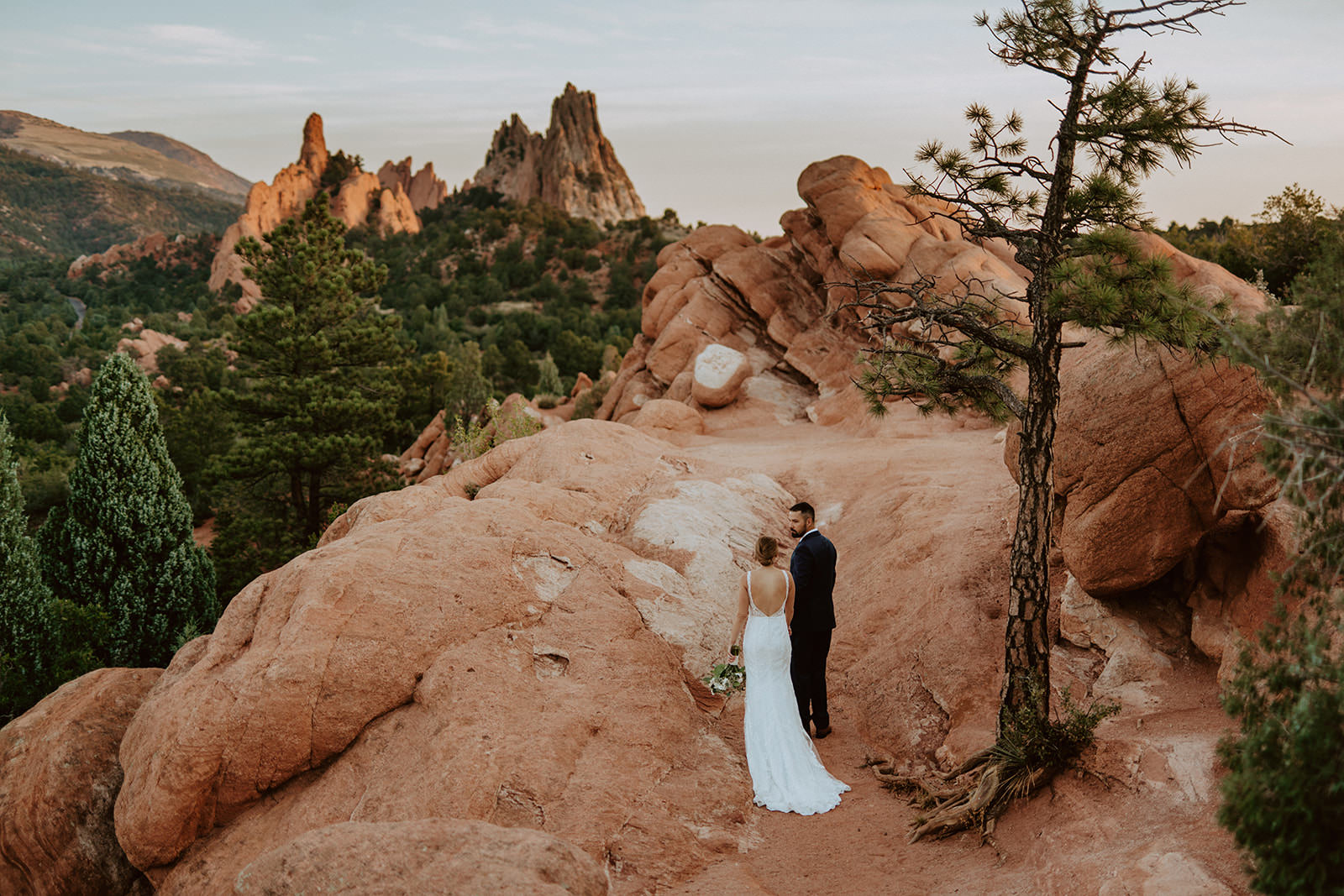Brittney and Jesse walking along the red rocks of Garden of the Gods on their wedding day in Colorado Springs.
