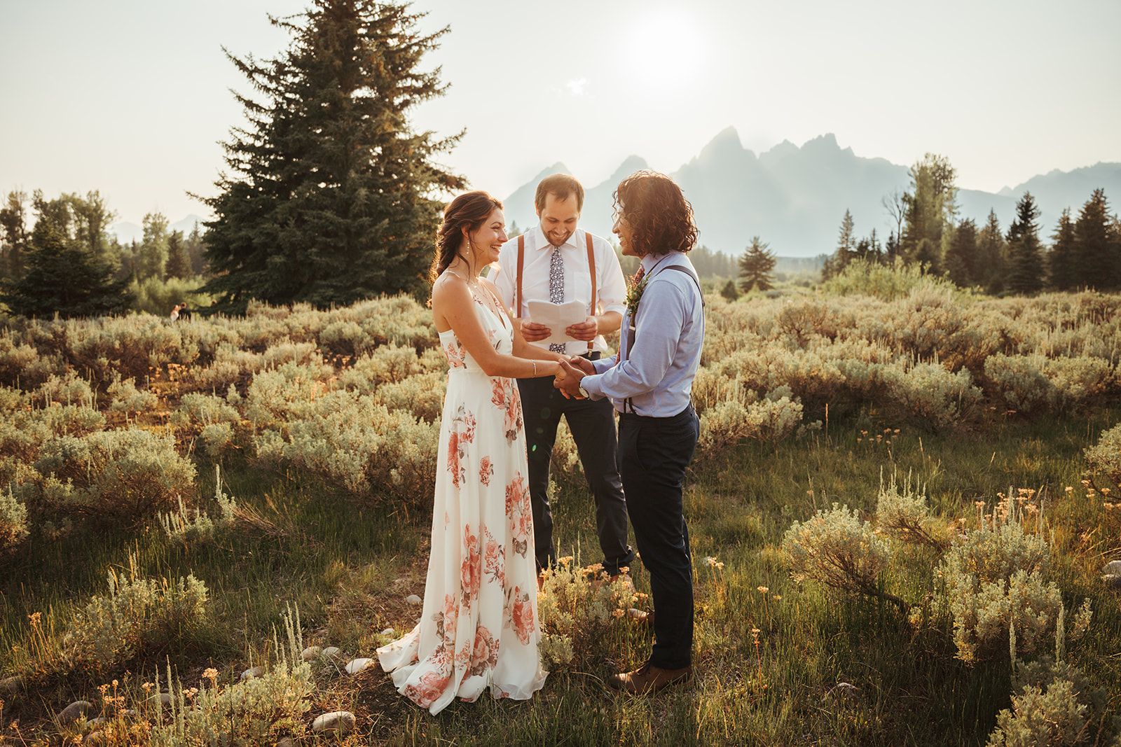 A couple exchanging vows during their Grand Teton elopement at Schwabacher's Landing.